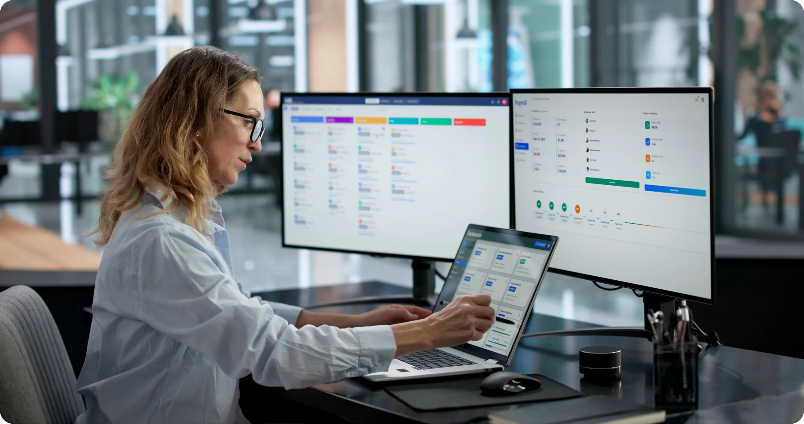 Woman working with multiple computer screens.